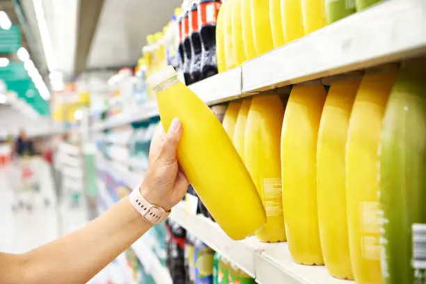 Orange juice in the hands of a buyer in a store