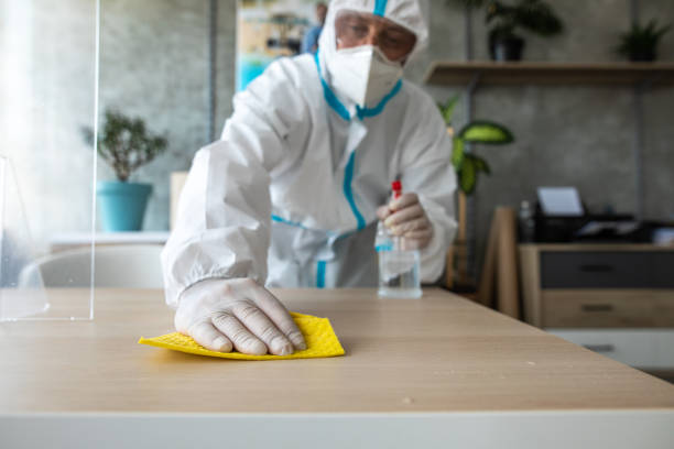 istock Man in protective suit disinfecting and cleaning bank workspace 1262291708