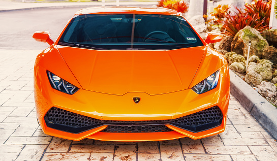 Miami, Florida, USA-February 19, 2016: Supercar Lamborghini Aventador orange color parked next to Ocean drive at South bech at Miami, Florida. Lamborghini car is famous expensive automobile brand car