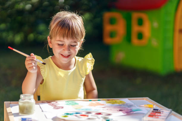 istock Happy girl smiling while painting 1262294074