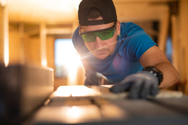 istock Manual worker using circular saw while cutting pice of wood at construction site. 1262294311