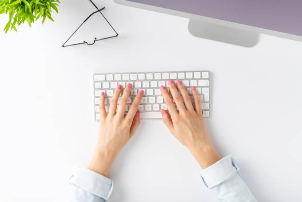 istock Woman’s hands working on computer with accessories on white background. Office desktop. Top view 1262294705