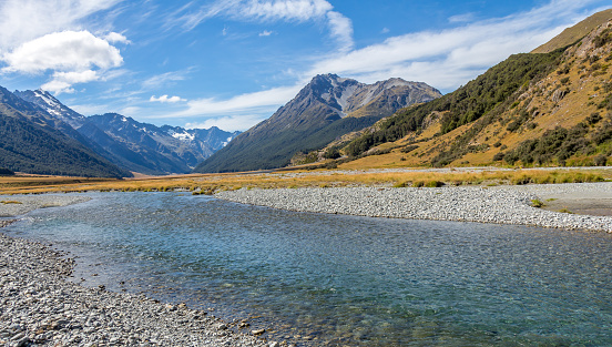 A shallow, fast flowing river, in the mountains of New Zealand on a sunny day, near Canterbury, South Island