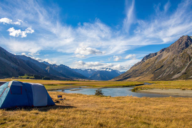 A tent pitched beside the Ahuriri River, surrounded by mountains, in New Zealand A tent pitched beside the Ahuriri River, surrounded by mountains, in Cantebury, South Island, New Zealand omarama stock pictures, royalty-free photos & images