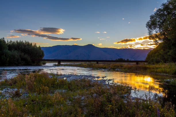 istock Sunset on the Tekapo River, with mountains in the background in summer 1262300778