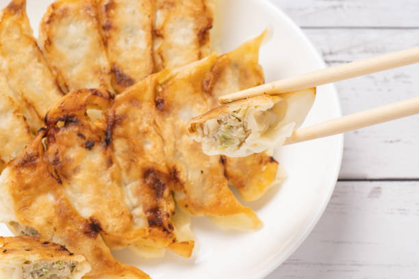 dumplings on a white dish with a white wood grain background