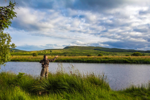 A fisherman fly fishing in the evening on the Blackwater of Dee, Scotland A fisherman fly fishing in the evening sun on the Blackwater of Dee, Galloway, Scotland Galloway Hills stock pictures, royalty-free photos & images