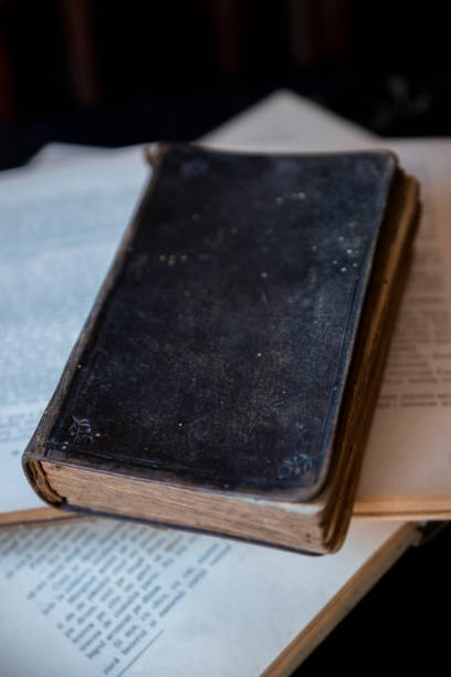 istock Old holy Bible and books on wooden table 1262302106