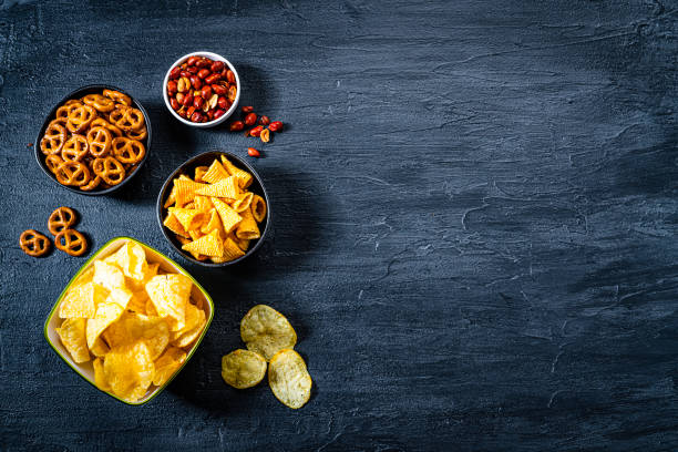 istock Salty snacks assortment shot from above on dark slate table. Copy space 1262304153