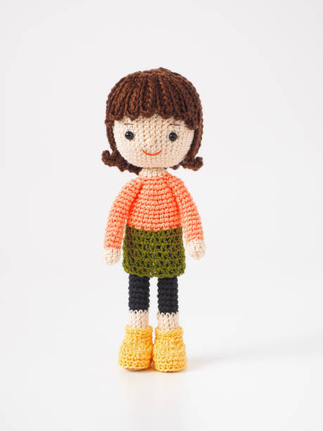 Home made rag doll with red yarn hair. Black and white checkered dress with pinafore apron. white pantalones.Black shoes. Sitting position on white background.http://www.garyalvis.com/images/familyLife.jpg