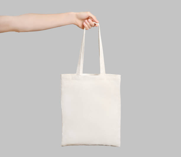 Hand with eco bag Male hand holding eco bag isolated on white background. shopping bag stock pictures, royalty-free photos & images