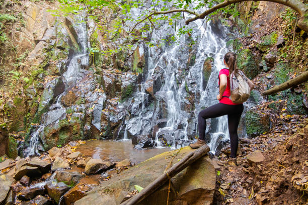 istock Young woman near the waterfall 1262319917