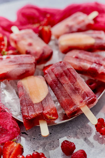 istock Strawberry raspberry apple and red currant ice cream popsicles in metal tray with ice cubes 1262327398