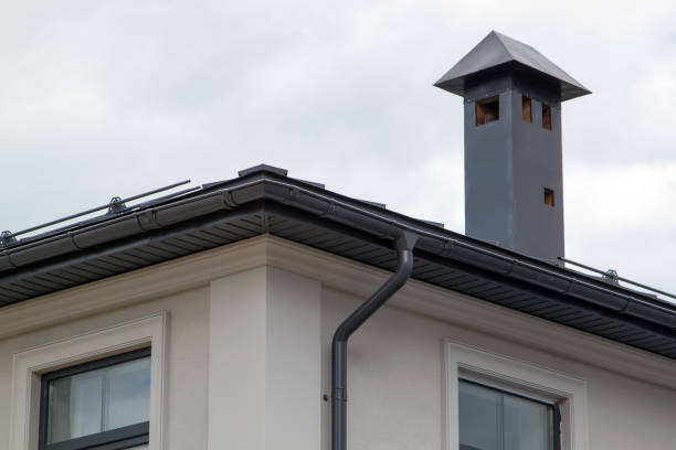 vista de cerca de la casa con techo de pliegue gris y ciruelas y archivo de voladizos de techo con sofitos y tubo de piedra de ladrillo cubierto con hojas de metal y caja de humo negro - roof repairing roofer chimney fotografías e imágenes de stock