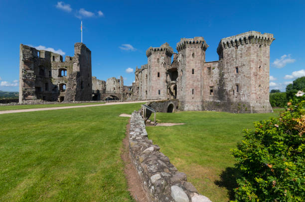 Raglan Castle is a late medieval castle located just north of the village of Raglan in Monmouthshire, South East Wales. The modern castle dates from between the 15th and early 17th centuries.\nSurrounded by parkland, water gardens and terraces, the castle was considered by contemporaries to be the equal of any other castle in England or Wales.