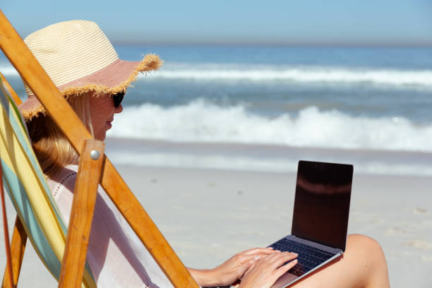 istock Caucasian woman using her laptop seaside 1262331634