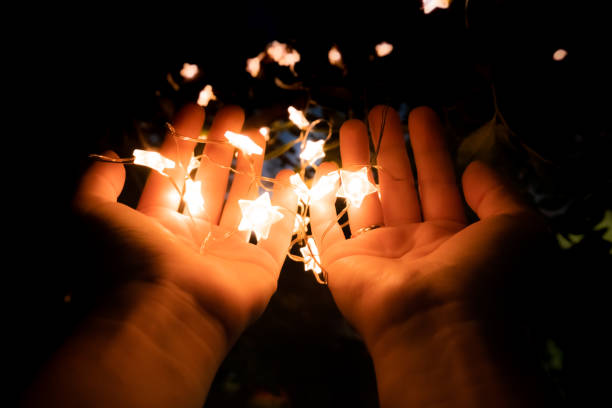 istock Yellow Led star shape light on hands in shape of pray for background. 1262332043