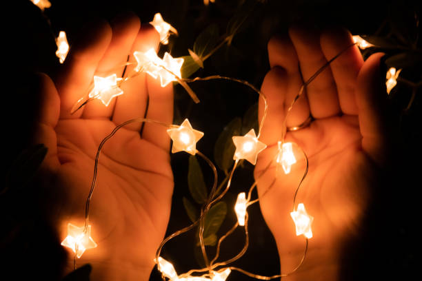 istock Yellow Led star shape light on hands in shape of pray for background. 1262332078