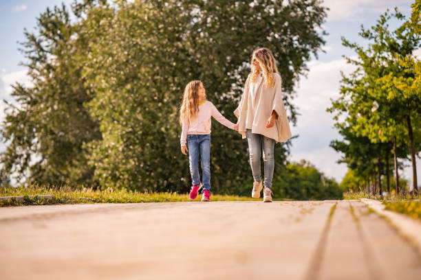 istock Mom and daughter walking together 1262337394