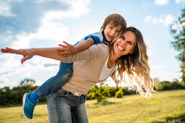 istock Mom is holding son in public park 1262339955
