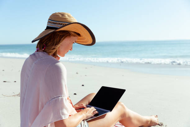 istock Caucasian woman using her laptop seaside 1262341483