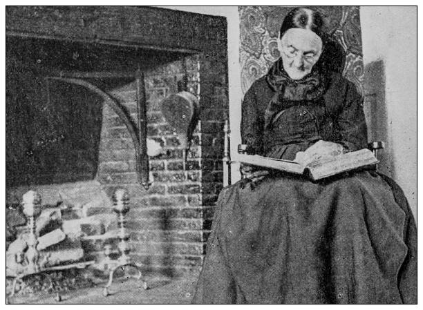 istock Antique black and white photo: Old woman reading 1262343071