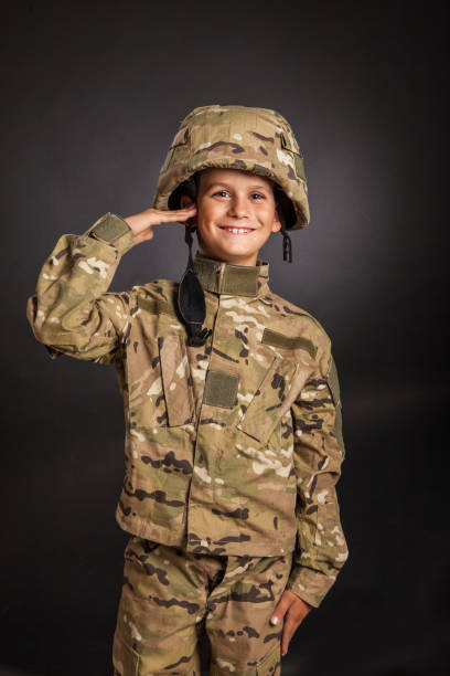 istock Saluting soldier. Young boy dressed like a soldier 1262346024