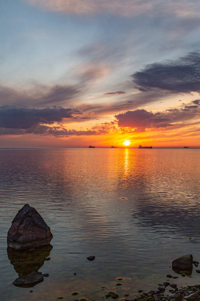 istock July Sunset and clouds at sea with ships in the background 1262346942