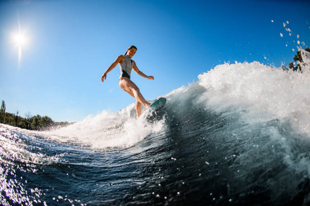 istock active young wet woman masterfully rides the wave on surfboard 1262349411