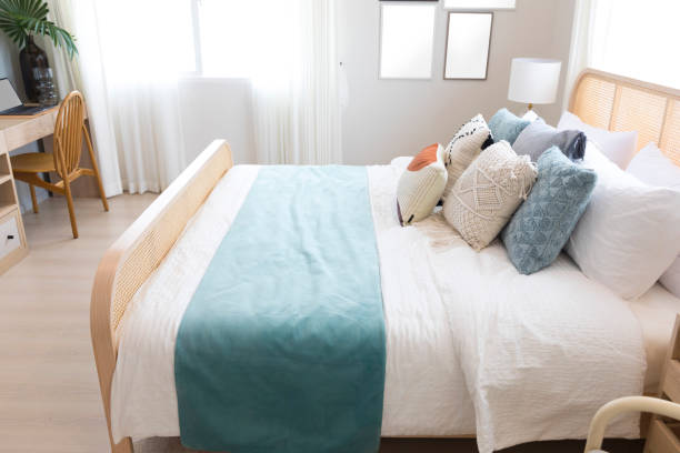 istock Elegant bedroom interior with lamps over bedside tables, comfortable bed, blue pillow and blanket. 1262349708
