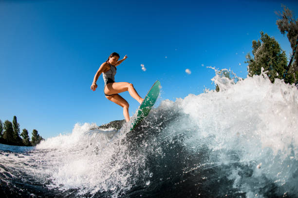istock young wet woman energetically balancing on wave on wakesurf board 1262352604