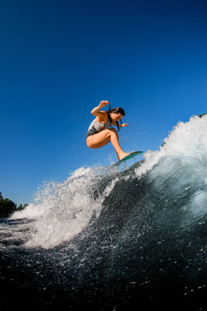 istock young woman skillfully jumping on a wave on a wakesurf board 1262354669