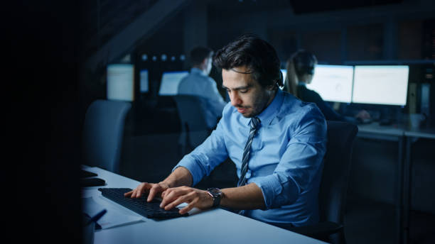 istock In the Office at Night Overworked Tired Office Worker Uses Desktop Computer but Falls Asleep Fast. Tired Exhausted Businessman Falls asleep at His Job 1262359202