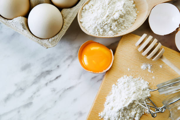 istock Baking utensils and ingredients with eggs, wheat flour, egg yolks for pastry. Cake, pasta or dough recipe ingredients. Top view 1262360253