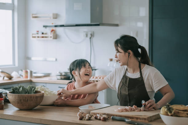 una madre china asiática cocinando preparando comida en el mostrador de la cocina con su hija - asian cuisine audio fotografías e imágenes de stock