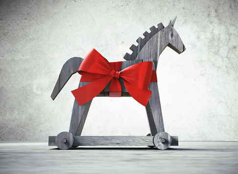 Trojan horse with red satin bow as symbol for computer virus with stone background