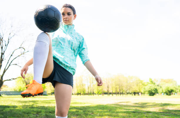 istock Young woman practicing soccer skills with ball. 1262361937