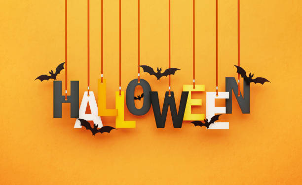 Halloween written by hanging letters and flying bats over orange background. Horizontal composition with copy space. Halloween concept.