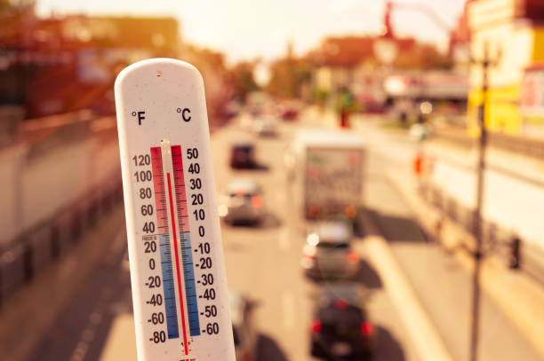 Thermometer in front of cars and traffic during heatwave in Montreal. stock photo
