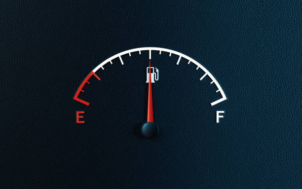 fuel gauge's red needle indicating half full gas tank on black background - half tank imagens e fotografias de stock