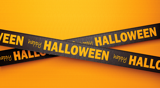 Happy Halloween written black ribbons over yellow background. Horizontal composition with copy space.  Halloween concept.