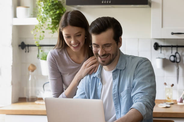 istock Happy young couple relax on kitchen using laptop together 1262376549