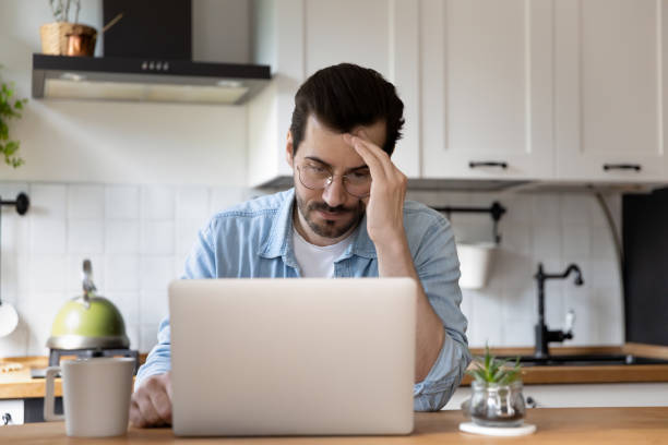 istock Unhappy young man distressed by email on laptop 1262376558