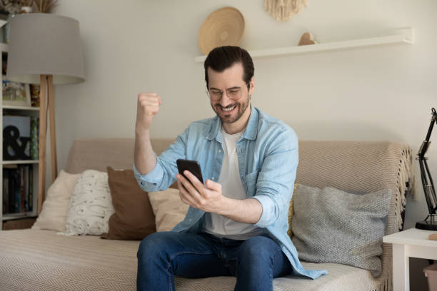 istock Overjoyed young man excited with win on cellphone 1262376608