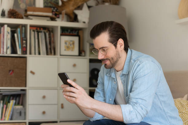 istock Young man relax at home browsing modern cellphone 1262376610