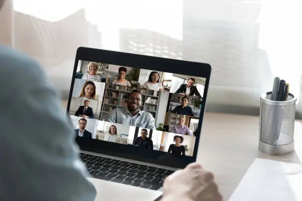 Photo of Back view of male employee have webcam conference with colleagues