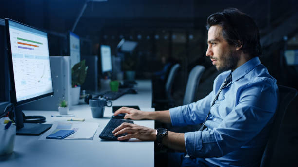 istock In the Office at Night Overworked Tired Office Worker Uses Desktop Computer Yawning. Tired Exhausted Businessman Finishing Important Project 1262376863