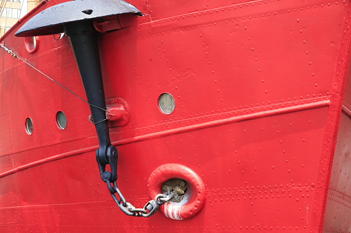 Detail of an anchor hanging off the side of a ship