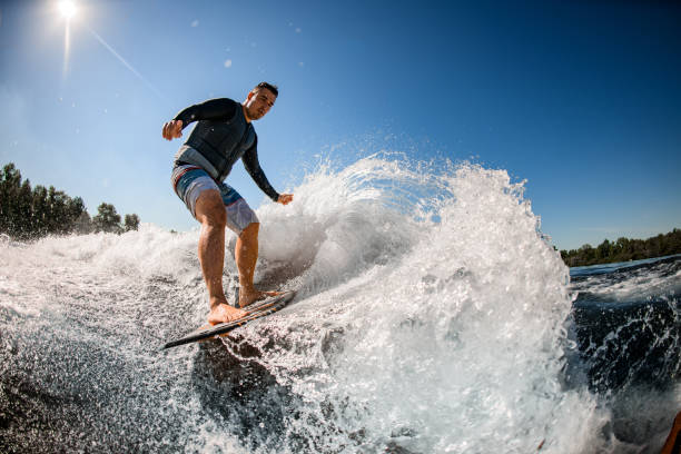 istock male wakesurfer rides the wave on surfboard 1262378399