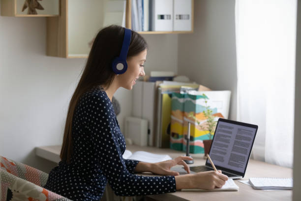 istock Smiling millennial girl study on laptop at home 1262378638